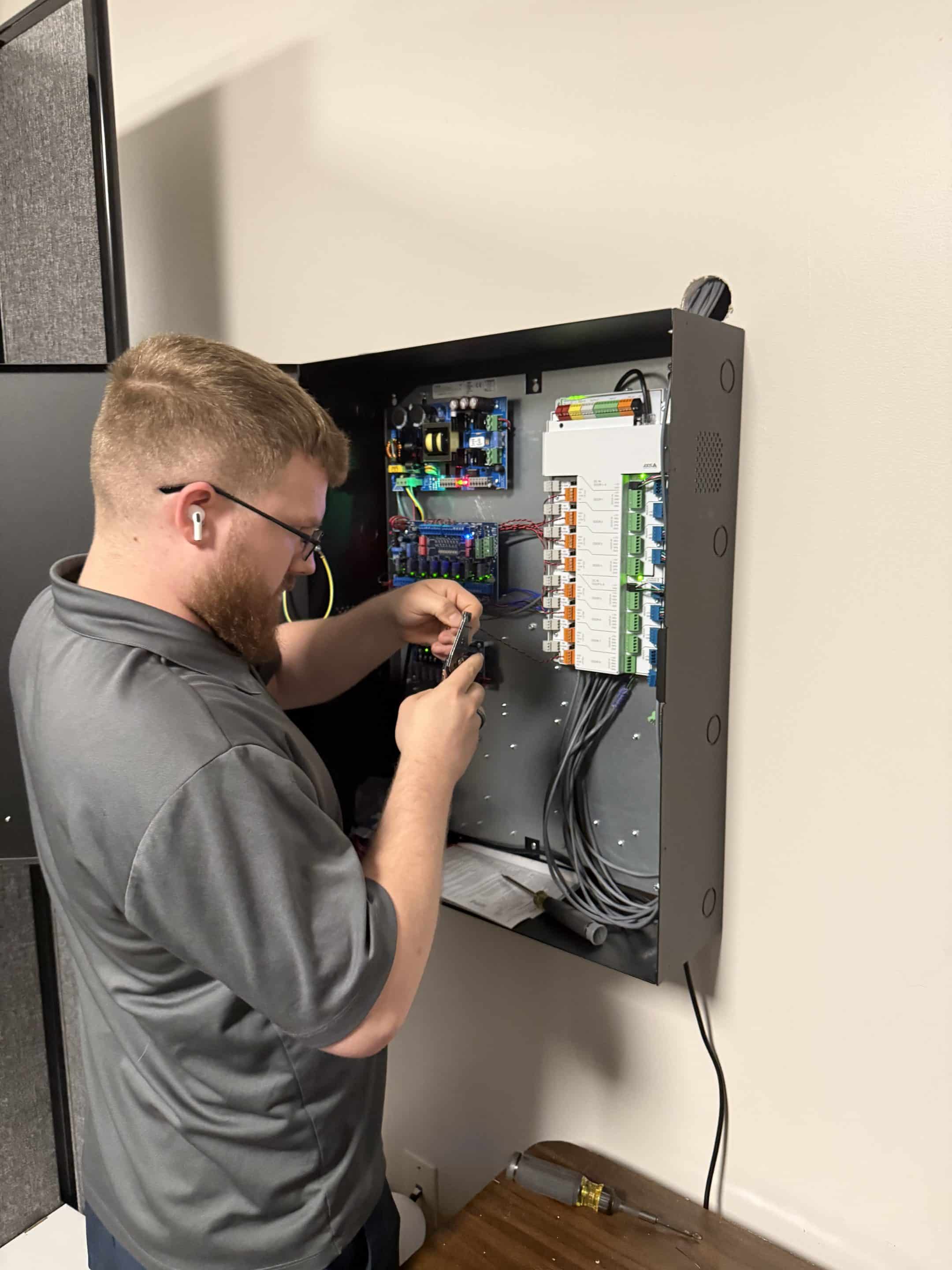 Axis Communications Access Control Review 9 Umbrella technicians working on access control door panel wiring