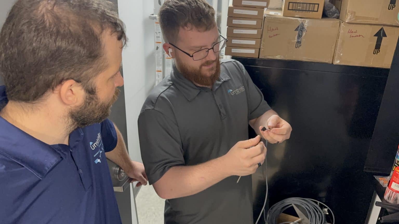 Umbrella Security technicians reviewing access-control wiring and door hardware conditions.