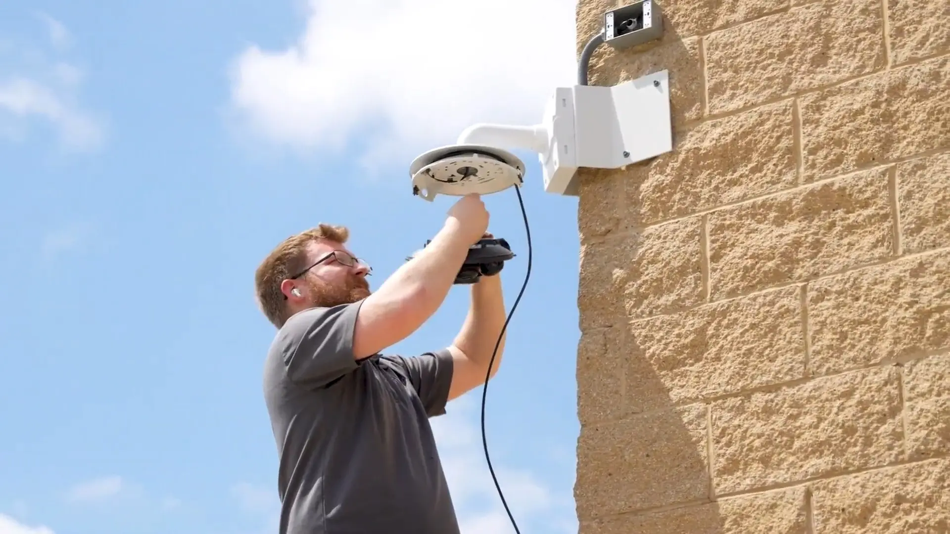 Wilmington Police and City Hall Security Modernization 14 Umbrella Security technician mounting an exterior network camera on a Wilmington municipal building wall